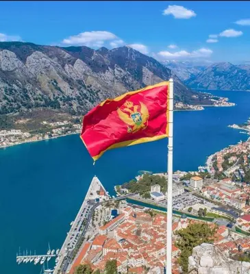 a red and yellow flag on top of a city at Studio Apartment Silva in Kotor