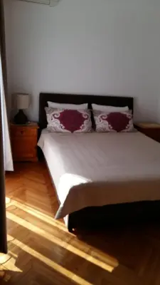 a bedroom with a bed with red pillows on it at Lazar Apartments in Petrovac na Moru