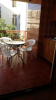 a table and chairs on a balcony with a kitchen at Lazar Apartments in Petrovac na Moru
