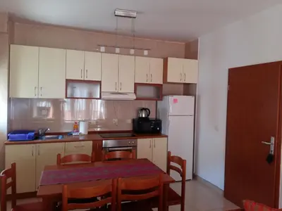 a kitchen with a table and a white refrigerator at Lazar Apartments in Petrovac na Moru