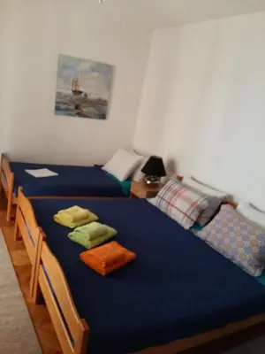 two beds in a room with blue sheets at Lazar Apartments in Petrovac na Moru