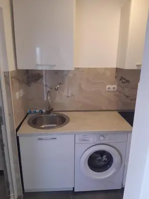 a kitchen with a sink and a washing machine at Apartments Mušović in Bar