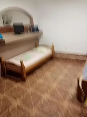 a small bed in a room with a mirror at Apartments Mušović in Bar