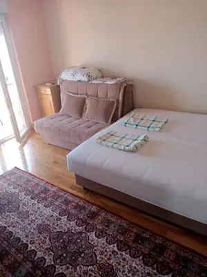 a small bedroom with a bed and a couch at Apartments Mušović in Bar