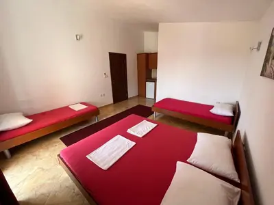 a room with two beds with red and white sheets at Apartments Zati in Ulcinj