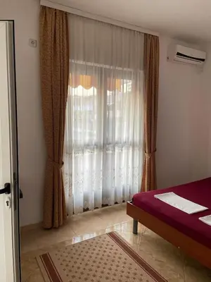a bedroom with a bed and a window with curtains at Apartments Zati in Ulcinj