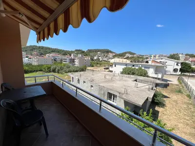 a balcony with a table and a view of a ballpark at Apartments Zati in Ulcinj