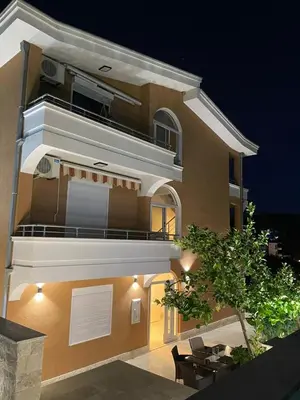 a large building with a balcony at night at Apartments Zati in Ulcinj