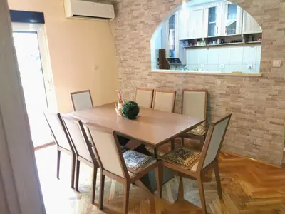 a dining room with a wooden table and chairs at Apartment City View in Kotor