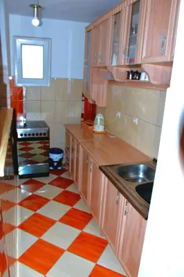 a kitchen with wooden cabinets and a checkered floor at Apartment City View in Kotor