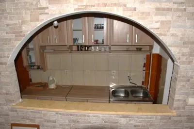 a kitchen with a sink and a brick wall at Apartment City View in Kotor