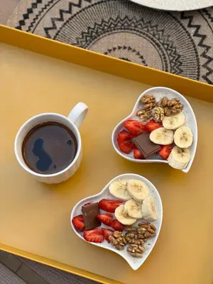 a table with two plates of fruit and a cup of coffee at Apartment City View in Kotor