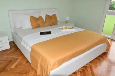 a large bed with a tray of food on it at Apartment City View in Kotor