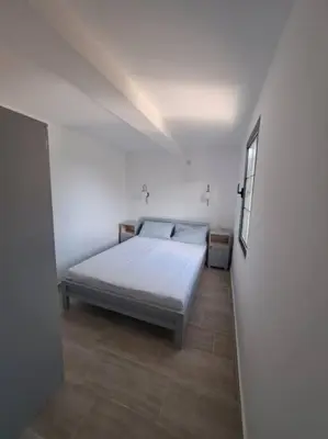 a bedroom with a bed in a white room at Once Upon a Time in Montenegro in Sutomore