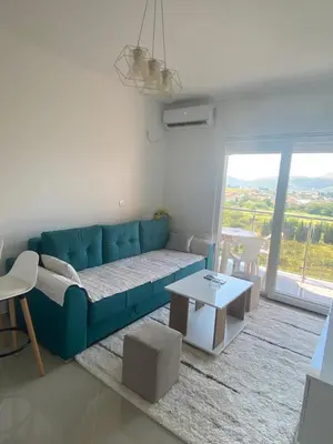 a living room with a blue couch and a table at Jelena apartment Bar in Bar