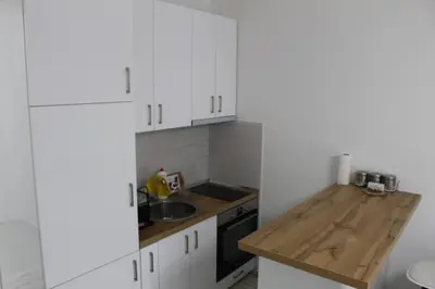 a kitchen with white cabinets and a wooden counter top at Jelena apartment Bar in Bar