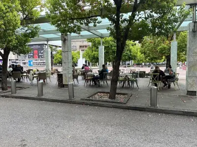 a group of people sitting at tables in a park at Moderan Studio na Trgu Republike - Centar in Podgorica