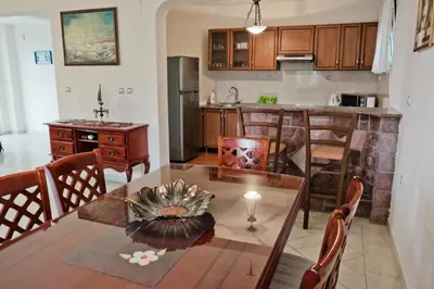 a kitchen and dining room with a table and chairs at Apartments Klara in Utjeha