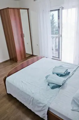 a bedroom with a bed with blue pillows on it at Apartments Klara in Utjeha