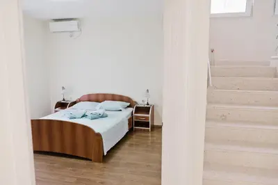 a bedroom with a bed and a staircase at Apartments Klara in Utjeha