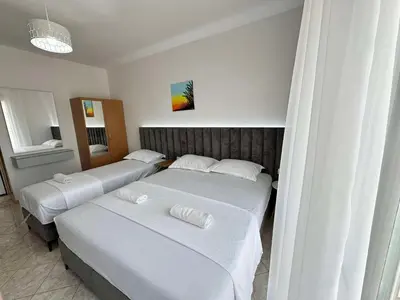 two beds in a hotel room with white sheets at Apartments Ela in Ulcinj