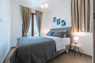a bedroom with a bed and a large window at Niki Apartments Pržno in Sveti Stefan