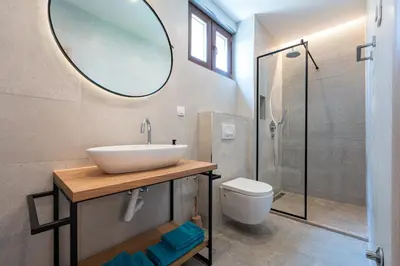 a bathroom with a sink and a toilet and a mirror at Niki Apartments Pržno in Sveti Stefan