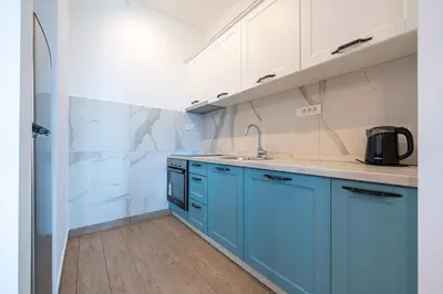 a kitchen with blue cabinets and a sink at Niki Apartments Pržno in Sveti Stefan