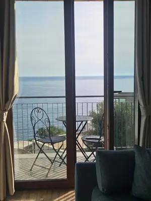 a room with a balcony with a table and chairs at Niki Apartments Pržno in Sveti Stefan