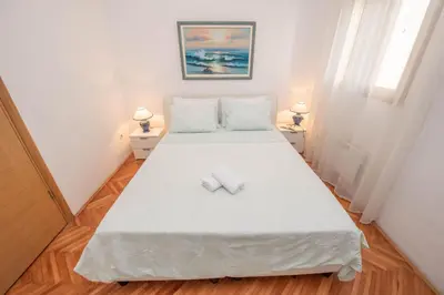 a bedroom with a bed with two towels on it at S&P City Center Apartments in Kotor