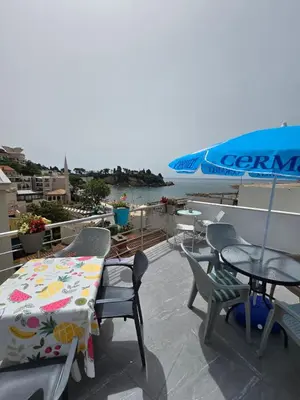 a patio with a table and chairs and an umbrella at Apartmani Liki in Ulcinj