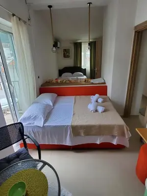 a bedroom with two beds and a large window at Apartmani Liki in Ulcinj