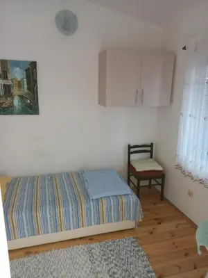 a bedroom with a bed and a chair in it at Apartmani Liki in Ulcinj