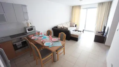 a kitchen and living room with a table and chairs at Petrovac Bay Apartments in Petrovac na Moru