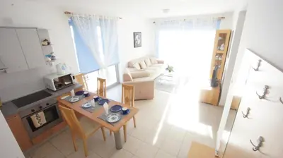 a small living room with a table and a kitchen at Petrovac Bay Apartments in Petrovac na Moru