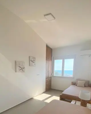 a white room with two beds and a window at Ačanski Apartments Bar in Bar