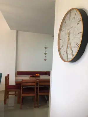 a clock hanging on a wall next to a table at Ačanski Apartments Bar in Bar