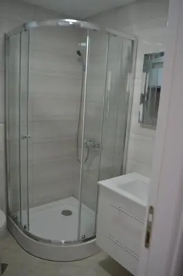 a glass shower in a bathroom with a sink at Ačanski Apartments Bar in Bar