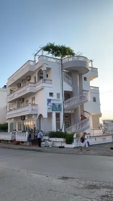a large white building with people standing in front of it at Apartments Delfin in Ulcinj
