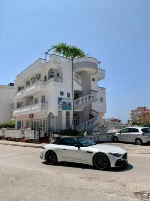 a white car parked in front of a building at Apartments Delfin in Ulcinj