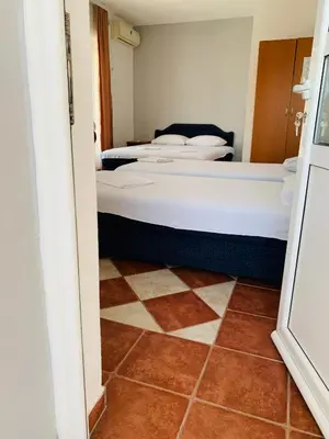 a room with three beds and a tiled floor at Apartments Delfin in Ulcinj