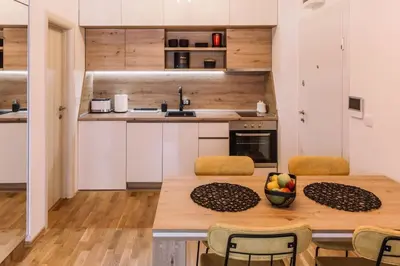 a kitchen with a wooden table and chairs at MT One-bedroom boho apartment, Budva in Budva