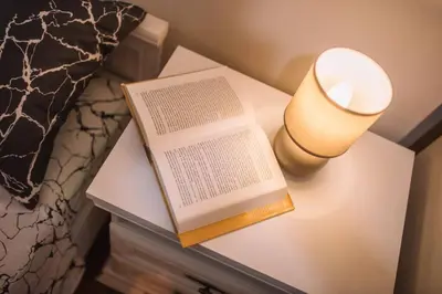 a book and a candle on a nightstand next to a bed at MT One-bedroom boho apartment, Budva in Budva