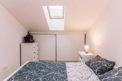 a attic bedroom with a bed and a window at MT One-bedroom boho apartment, Budva in Budva