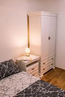a bedroom with a bed and a dresser and a cabinet at MT One-bedroom boho apartment, Budva in Budva