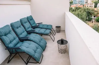 a group of chairs sitting on a balcony at MT One-bedroom boho apartment, Budva in Budva