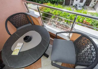 a table and a chair on a balcony at Adzic Apartments in Budva