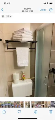 a bathroom with a shower and a toilet and towels at Adzic Apartments in Budva