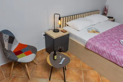 a bedroom with a bed and a table and a chair at Adzic Apartments in Budva