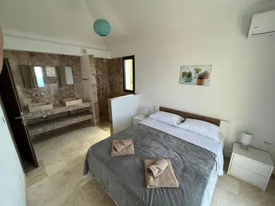 a bedroom with a bed and a bathroom with a shower at Family Vacation Villa Rezevici in Budva